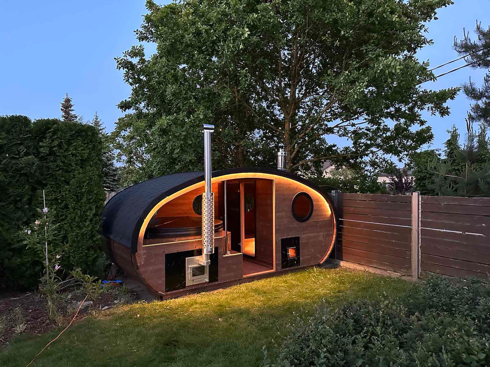 "Un'oasi di benessere all'aperto: Sauna ovale con vasca jacuzzi idromassaggio incassata in elegante legno"